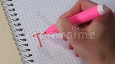 一个女人的手在记事本上用粉红色的记号笔写着“谢谢”这个词。